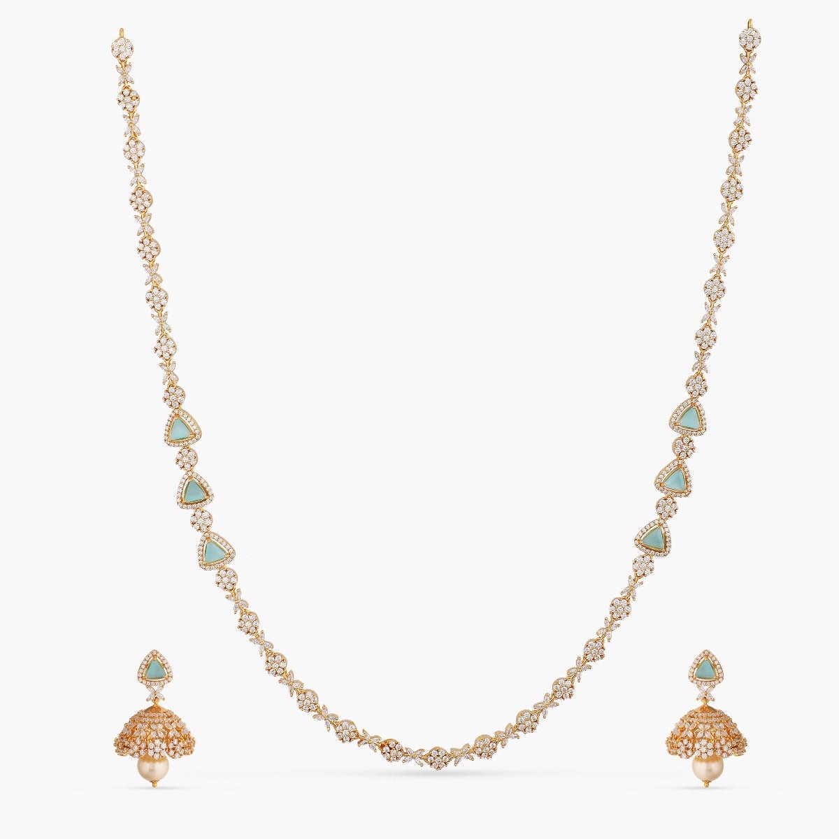 A picture of an Indian artificial jewelry set with a gold-toned necklace and matching earrings, featuring Cubic Zirconia and green stones.