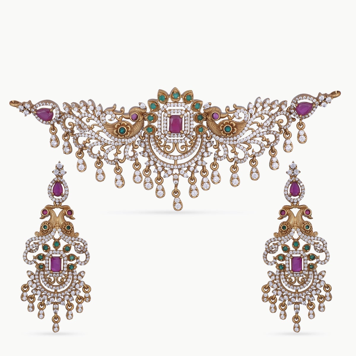 A picture of an Indian artificial jewelry set consisting of a gold-colored necklace and matching earrings adorned with colorful gemstones.